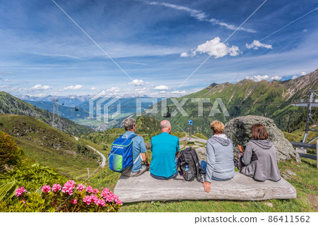 Tourists are watching the lake among Austrian Alps and cable cars in Zell am See-Kaprun region, Austria Tourists are watching the lake among Austrian Alps and cable cars in Zell am See-Kaprun region, Austria 86411562