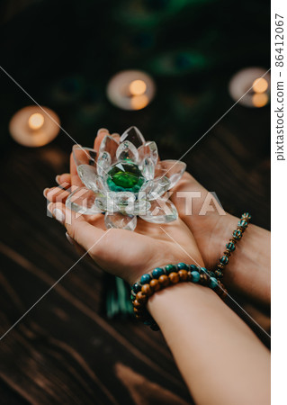 Woman holding fragile crystal lotus flower. Concept of religion, art, meditation, chakras, spiritual 86412067