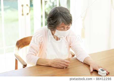 Senior female using a pulse oximeter 86412298