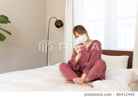 A woman who measures body temperature 86412440