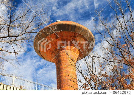 Blue sky and brown rusty UFO-like water tower Blue sky and brown rusty UFO-like water tower 86412973