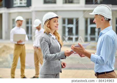 Inspector handing over the building documentation to a chief engineer 86414963