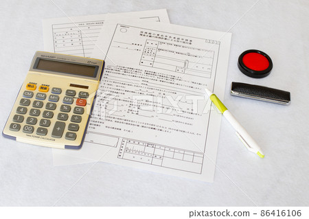 藍色申報審批申請書、計算器、印章、圓珠筆桌照片 86416106