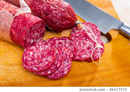 Slices of dry-cured sausage from Iberian pork seasoned with natural marinades 86417572