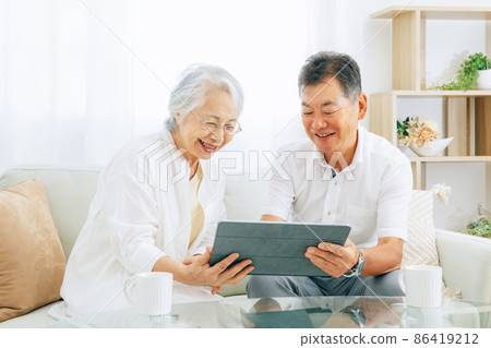 Elderly couple looking at a tablet PC (smile) 86419212