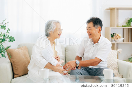 Elderly females and men holding grandchildren Elderly females and men holding grandchildren 86419245