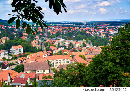 View over trees and bushes to the roofs of the small town Blankenburg in Saxony-Anhalt, Germany, at the northern edge of the Harz Mountains View over trees and bushes to the roofs of the small town Blankenburg in Saxony-Anhalt, Germany, at the northern edge of the Harz Mountains 86423422