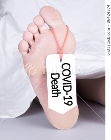 Body with toe tag on white 86424874