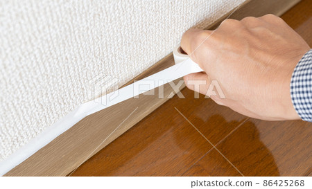 Image of closing the gap between skirting boards and skirting boards with masking tape Image of closing the gap between skirting boards and skirting boards with masking tape 86425268