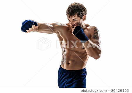 Studio shot of kickboxer who training, practicing jab on white background. Blue sportswear Studio shot of kickboxer who training, practicing jab on white background. Blue sportswear 86426103