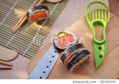 Closeup of sushi with chopsticks on a wooden background. Japanese cuisine, sushi. Closeup of sushi with chopsticks on a wooden background. Japanese cuisine, sushi. 86426565