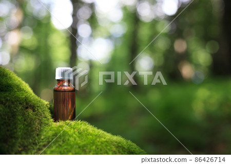 Herbal oil on moss, green bokeh background. MOCK-UP Alternative Medicine. Herbal oil on moss, green bokeh background. MOCK-UP Alternative Medicine. 86426714