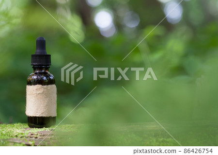 Herbal oil on moss, green bokeh background. Mockup - Alternative Medicine. 86426754
