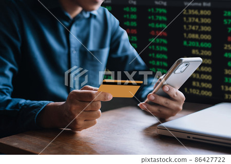 Businessmen trading stocks online. Stock brokers looking at graphs, indexes and numbers on smartphone and laptop. Business success concept. Businessmen trading stocks online. Stock brokers looking at graphs, indexes and numbers on smartphone and laptop. Business success concept. 86427722