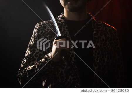 Bearded person playing with imitation sword 86428080