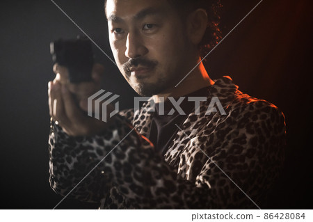 Bearded person playing with a model gun Bearded person playing with a model gun 86428084