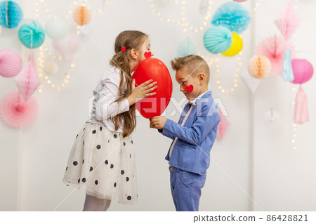 Cute couple of kids with red heart balloon. Cute couple of kids with red heart balloon. 86428821