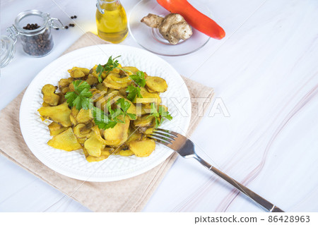 A plate of roasted jerusalem artichoke on the table with a napkin. A plate of roasted jerusalem artichoke on the table with a napkin. 86428963
