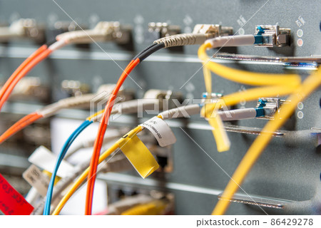 detail of server rack with fiber optic cables attached to front panel switch ports detail of server rack with fiber optic cables attached to front panel switch ports 86429278