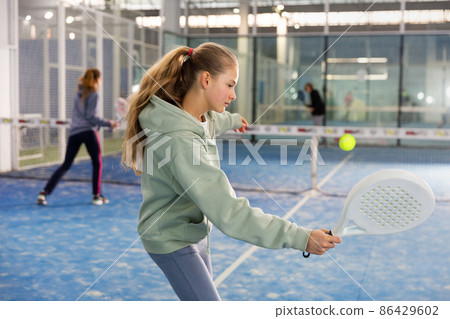 Girl tennis player playing padel tennis Girl tennis player playing padel tennis 86429602