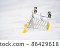 Empty inverted shopping cart on white marble background. Stainless steel shopping trolley upside down. Business, mall, market, shopping concept. 86429618