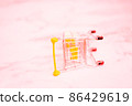 Empty inverted shopping cart on white marble background. Stainless steel small miniature toy shopping trolley on table. Business, mall, market, shopping concept. 86429619