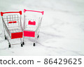 Shopping, purchases, supermarket, sale, mall concept. Two empty metal small miniature toy shopping trolley on light background. Selective focus. 86429625