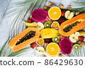 Group of exotic tropical fruits. Papaya, mango, dragon fruit, passion fruit, kiwi, strawberry, apple, banana, orange, longan, green leaves on white background Top view Flat lay 86429630