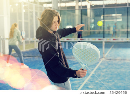 Teenage guy playing paddle tennis on padel court Teenage guy playing paddle tennis on padel court 86429666