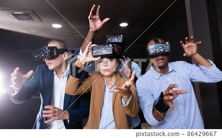 People using virtual reality glasses delighted with videogames People using virtual reality glasses delighted with videogames 86429667