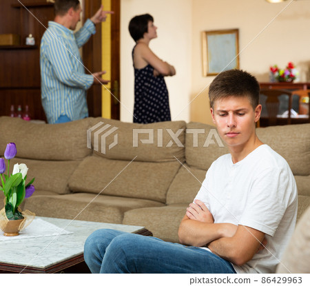 Spouses quarrelling while their son sitting 86429963