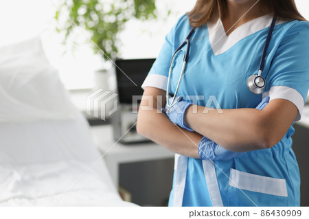 Woman doctor with crossed arms standing in hospital ward closeup 86430909