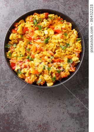 Anda Bhurji is an Indian Style Spicy Scrambled Eggs closeup in the plate. Vertical top view 86432228