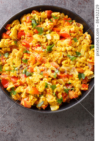 Egg bhurji is a scrambled eggs dish which is a popular Indian street food and a breakfast, lunch or dinner recipe closeup in the plate. Vertical top view 86432229