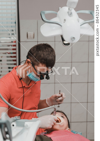 Dental treatment of a child, removal of caries with a drill, open mouth and ejector saliva. Dental treatment of a child, removal of caries with a drill, open mouth and ejector saliva. 86432345
