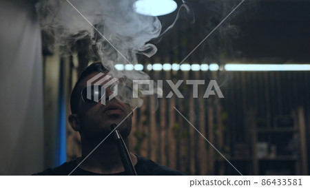 Arabic jordanian young man smokes a hookah. Arabic jordanian young man smokes a hookah. 86433581