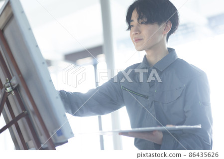 一個穿著工作服畫油畫的年輕學生 86435626