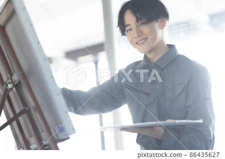 一個穿著工作服畫油畫的年輕學生 86435627