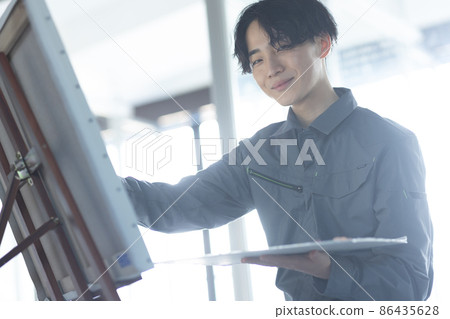 一個穿著工作服畫油畫的年輕學生 86435628