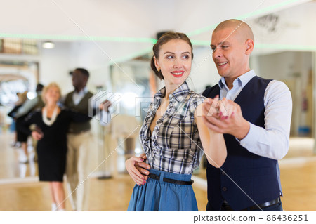 Man and woman performing ballroom dance in dancing room 86436251