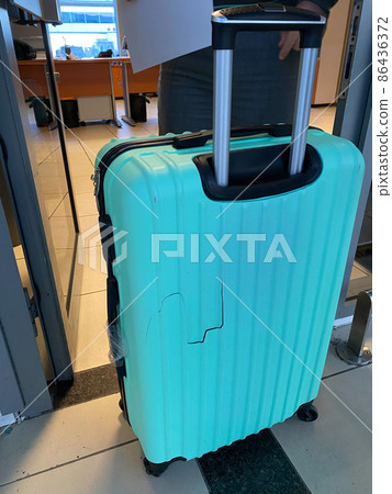 Broken blue suitcase at the airport. Incident with luggage during the flight. 86436372