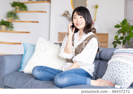 A young woman operating a smartphone A young woman operating a smartphone 86437272