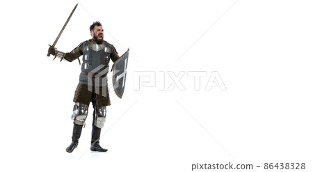 Portrait of brutal seriuos man, medieval warrior or knight with sword and shield isolated over white background. Portrait of brutal seriuos man, medieval warrior or knight with sword and shield isolated over white background. 86438328