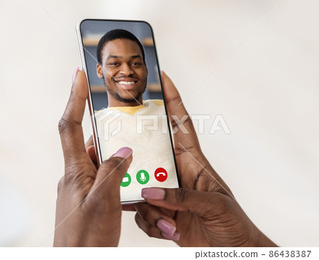 Black woman holding cellphone in hand video calling boyfriend Black woman holding cellphone in hand video calling boyfriend 86438387