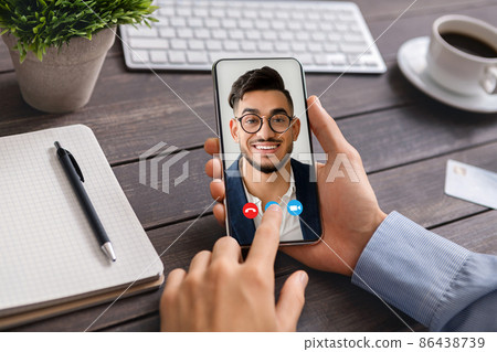 Businessman having online meeting with coworker on smartphone, sitting at workplace, collage Businessman having online meeting with coworker on smartphone, sitting at workplace, collage 86438739