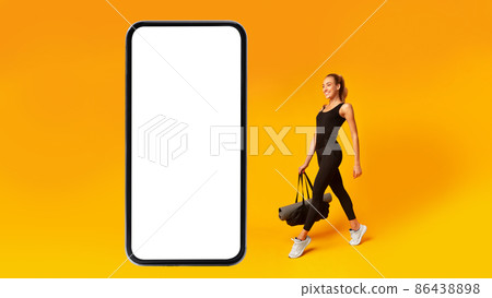 Fitness Woman Walking To Big Smartphone Blank Screen, Yellow Background 86438898