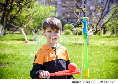 Happy boy is playing tetherball swing ball game in summer camping. Happy leisure healthy active time outdoors concept Happy boy is playing tetherball swing ball game in summer camping. Happy leisure healthy active time outdoors concept 86439738