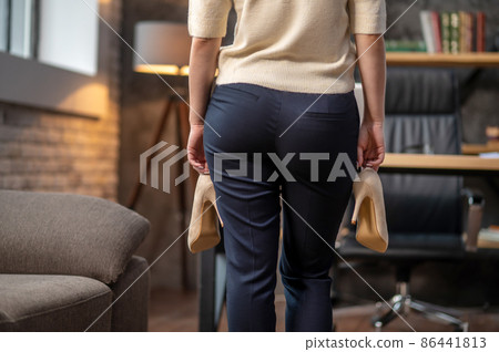Lady with high-heeled shoes standing in a room Lady with high-heeled shoes standing in a room 86441813