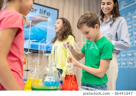 Boy taking liquid from test tube with pipette Boy taking liquid from test tube with pipette 86441847