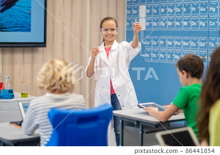 Girl showing test tube and kids with gadgets 86441854